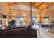 Bright living room with log walls, wood-burning stove, large windows, and dining area at 3945 Douglas Mountain Dr, Golden, CO 80403