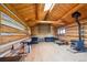 Open-concept living room with wood-paneled walls, hardwood floors, skylight, and wood-burning stove for cozy living at 3945 Douglas Mountain Dr, Golden, CO 80403