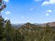 Scenic mountain view with trees and partial blue skies at 3945 Douglas Mountain Dr, Golden, CO 80403