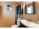 Bathroom featuring a vanity, mirror, toilet, and wall art at 1950 Jolene Dr, Denver, CO 80229