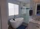 Luxurious bathroom featuring a soaking tub, separate glass-enclosed shower, and neutral color palette at 15945 Delta Ct, Brighton, CO 80603