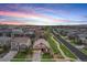 Wide aerial view of the neighborhood with a house with two car garage at sunset at 3480 Mount Powell Dr, Broomfield, CO 80023