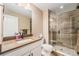 Elegant bathroom showcasing a single vanity, framed mirror and glass enclosed walk-in shower with stone floors at 3480 Mount Powell Dr, Broomfield, CO 80023