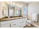 Bright bathroom featuring a double vanity with undermount sinks and wood-look tile flooring at 3480 Mount Powell Dr, Broomfield, CO 80023