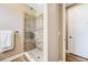 Bathroom featuring a walk-in shower with decorative tile and glass door, plus wood-look tile floors at 3480 Mount Powell Dr, Broomfield, CO 80023