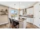Kitchen with island seating, stainless steel hood, and granite countertops with wood flooring at 3480 Mount Powell Dr, Broomfield, CO 80023