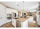 Modern kitchen with stainless appliances, a central island with seating, and open layout to the living area at 3480 Mount Powell Dr, Broomfield, CO 80023