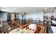 A large basement recreation room featuring polished concrete floors, a large rug, and stainless steel appliances at 46122 County Road 53, Bennett, CO 80102
