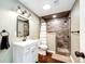 Modern bathroom featuring tile shower with pebble floor, vanity, and updated fixtures at 46122 County Road 53, Bennett, CO 80102
