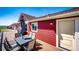 Spacious wooden deck showcasing outdoor dining and access to the home's exterior at 46122 County Road 53, Bennett, CO 80102