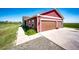 Exterior view of a two-story home with a two-car garage, concrete driveway, and a landscaped yard at 46122 County Road 53, Bennett, CO 80102