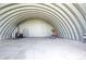Expansive steel garage interior with shelving, providing substantial space for storage and various uses at 46122 County Road 53, Bennett, CO 80102