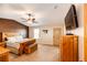 Well-lit bedroom with comfortable bed, ceiling fan, and mounted television set at 46122 County Road 53, Bennett, CO 80102