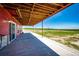 Covered patio offers ample space for outdoor activities and views of the backyard at 46122 County Road 53, Bennett, CO 80102