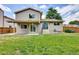 Spacious backyard with lush green grass, a covered patio, and sliding glass doors at 3973 S Joplin Way, Aurora, CO 80013