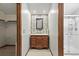Charming bathroom with a wood vanity, decorative mirror, and modern walk-in shower at 3973 S Joplin Way, Aurora, CO 80013