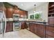 Modern kitchen with stainless steel appliances, granite countertops, and dark wood cabinetry at 3973 S Joplin Way, Aurora, CO 80013
