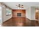 Cozy living room showcasing a brick fireplace and hardwood flooring at 3973 S Joplin Way, Aurora, CO 80013