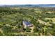 Aerial view of a modern home surrounded by lush greenery and scenic landscapes at 922 W Wolfensberger Rd, Castle Rock, CO 80109