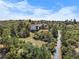 Stunning aerial view of a modern home nestled among trees with beautiful blue sky at 922 W Wolfensberger Rd, Castle Rock, CO 80109