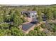 This aerial showcases a stylish home with a driveway and attached two-car garage amidst trees at 922 W Wolfensberger Rd, Castle Rock, CO 80109
