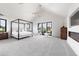 Spacious bedroom with a four-poster bed, fireplace, and scenic views from large windows at 922 W Wolfensberger Rd, Castle Rock, CO 80109