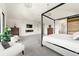 Large bedroom features a four-poster bed, cozy armchairs, and a modern fireplace with television at 922 W Wolfensberger Rd, Castle Rock, CO 80109