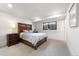 Cozy bedroom featuring a wooden bed frame, gray patterned bedding, and a bedside table with a lamp at 922 W Wolfensberger Rd, Castle Rock, CO 80109