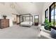 Bright, airy bedroom with a four-poster bed, white armchairs, and natural light from large windows at 922 W Wolfensberger Rd, Castle Rock, CO 80109
