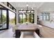 Open dining room with modern light fixture, seating for eight, hardwood floors and nature views at 922 W Wolfensberger Rd, Castle Rock, CO 80109