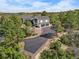 A modern two-story home with a three-car garage nestled in a wooded area with a paved driveway at 922 W Wolfensberger Rd, Castle Rock, CO 80109