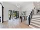 Grand foyer with wood staircase, hardwood floors, steel railing and black framed glass doors at 922 W Wolfensberger Rd, Castle Rock, CO 80109