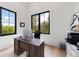 Well-lit home office with a modern desk and large windows offering natural light at 922 W Wolfensberger Rd, Castle Rock, CO 80109