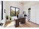 Bright home office with a large window, desk, white cabinets, and modern light fixture at 922 W Wolfensberger Rd, Castle Rock, CO 80109