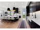 A modern, open-concept kitchen with an island, pendant lighting, and black cabinetry with gold hardware at 922 W Wolfensberger Rd, Castle Rock, CO 80109