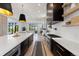 Bright, modern kitchen featuring a large island, custom hood, and views of the living room at 922 W Wolfensberger Rd, Castle Rock, CO 80109