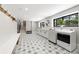 Well-lit laundry room with modern washer and dryer, stylish patterned flooring, and ample storage at 922 W Wolfensberger Rd, Castle Rock, CO 80109