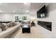 Comfortable living room with plush sofas, a modern fireplace, and a large flatscreen television at 922 W Wolfensberger Rd, Castle Rock, CO 80109