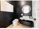Stylish powder room with dark walls, modern sink, and elegant gold mirror at 922 W Wolfensberger Rd, Castle Rock, CO 80109