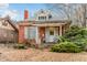Brick home with front porch, mature trees, and landscaping at 1317 S University Blvd, Denver, CO 80210
