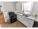 Simple kitchen with white cabinets and black appliances at 1317 S University Blvd, Denver, CO 80210