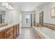 Spacious bathroom featuring double sink vanity, soaking tub, and glass-enclosed shower at 9826 E 27Th Dr, Denver, CO 80238