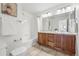 Well-lit bathroom with a double vanity, tile flooring, and a shower-tub combination, perfect for families at 9826 E 27Th Dr, Denver, CO 80238