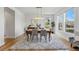 Elegant dining room featuring hardwood floors, a modern chandelier, and large windows providing plenty of natural light at 9826 E 27Th Dr, Denver, CO 80238