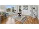 Bright home office with hardwood floors, a sit/stand desk, and large windows offering natural light and a comfortable workspace at 9826 E 27Th Dr, Denver, CO 80238