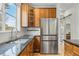 Modern kitchen featuring granite countertops, stainless steel appliances, and wooden cabinetry at 9826 E 27Th Dr, Denver, CO 80238