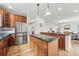 Open kitchen layout with stainless steel appliances, wooden cabinets, and a view into the living room at 9826 E 27Th Dr, Denver, CO 80238