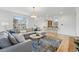 Open-concept living room with hardwood floors, a comfortable sectional sofa, and a view into the kitchen at 9826 E 27Th Dr, Denver, CO 80238