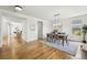 Open-concept dining room with hardwood floors, modern lighting, and access to the kitchen, great for entertaining guests at 9826 E 27Th Dr, Denver, CO 80238