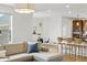 Bright living space flowing into kitchen and dining area, featuring hardwood floors and modern lighting at 9826 E 27Th Dr, Denver, CO 80238